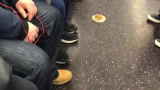 Lady eating off of small plate on subway floor