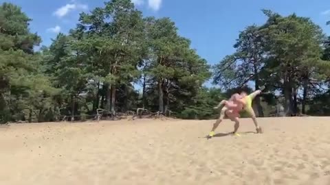 Men Perform Backflips and Cartwheels in Sand