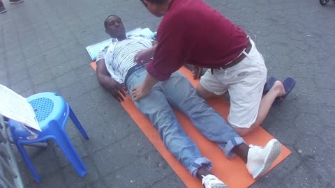 Luodong Massages Black Haitian Man On Sidewalk