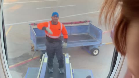 Kid Plays 'Rock, Paper, Scissors' With Airline Employee Loading Luggage