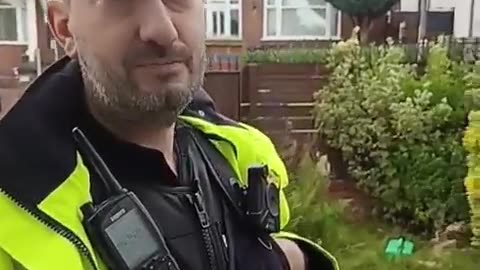 A UK police officer pays a home visit to a man for hanging a PALESTINIAN flag out of his window