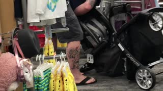 Man Struggles with Baby Stroller in Store