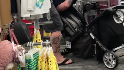 Man Struggles with Baby Stroller in Store