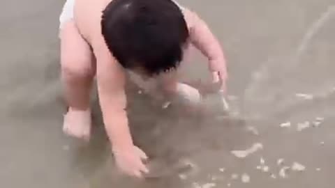 Funny baby reaction on the beach on short