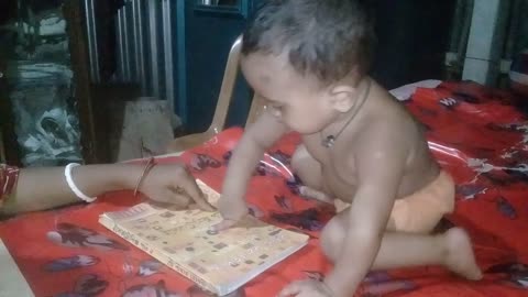 Baby reading a book before exam