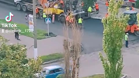 A Donetsk resident is watching from his balcony as Russian municipal services restore