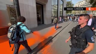 Environmental activists throw orange paint at a store in Paris.