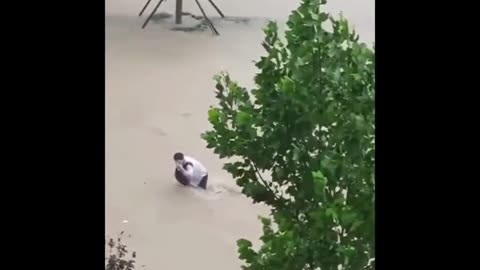 Locals rush to prevent woman from being swept away by floodwater in China