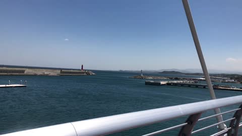 On a bridge over a windy sea.