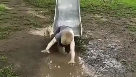 kid slides down slippery slide and ends up face first in a mud puddle.