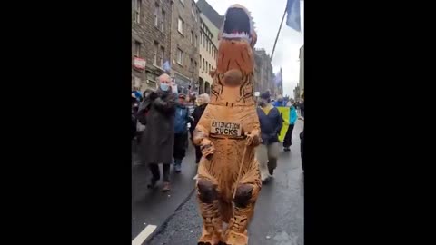 Protester in T-Rex suit calls for climate justice during COP26 in Scotland