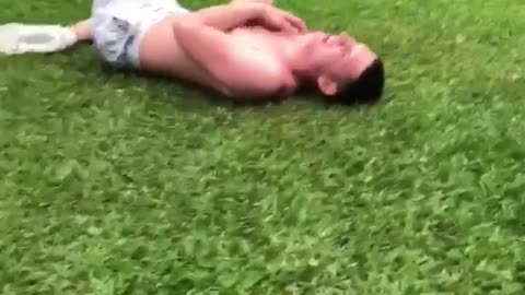 Guys swinging friend in hammock friend falls out onto grass