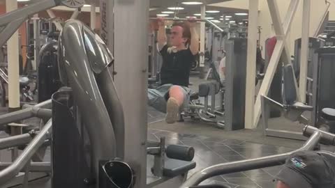 Guy with dwarfism at the gym, uses lat pulldown machine and flies up