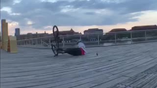 Guy back flip bike on beach pier