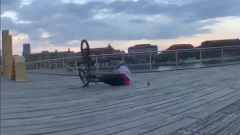 Guy back flip bike on beach pier
