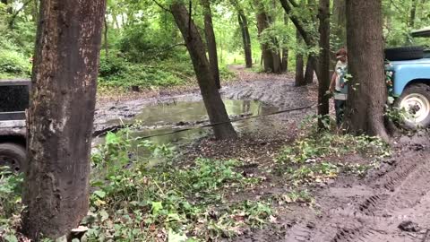 Vintage Old Land Rover Pulling Jeep Stuck in Mud