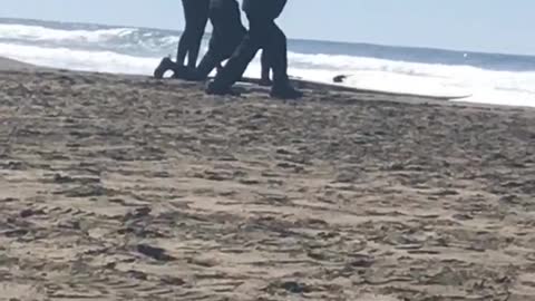 Guy in black jacket and black hat dancing on beach