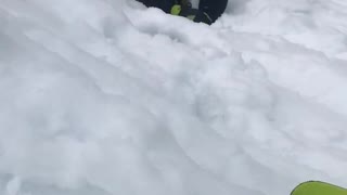 Guy black jacket green gloves stuck in snow