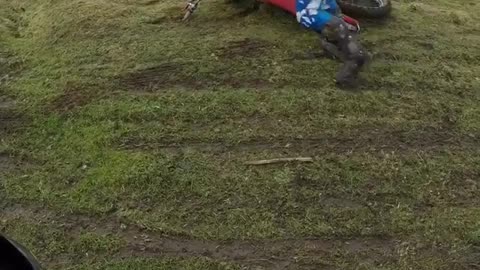 Bmx rider in blue falls off bike unto grass