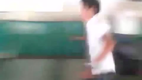 Young kid in school uniform falls after trying to jump fence