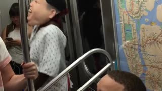 Person with head costume and hospital gown dancing in subway