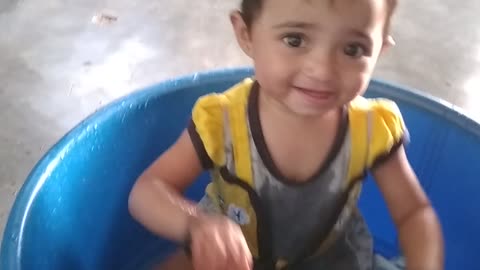 funny baby playing with water bucket