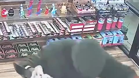 A wild black muslim intimidates a convenience store clerk with a machete