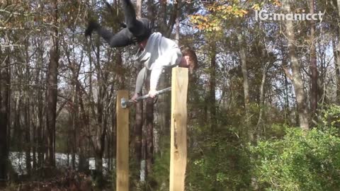 Guy grey shirt back flipping on pole forest