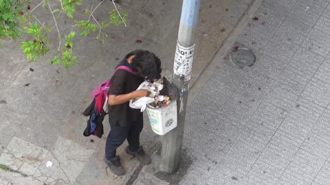 A hungry man eats garbage, it's sad