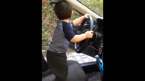 Toddler grooves to music while pretending to drive
