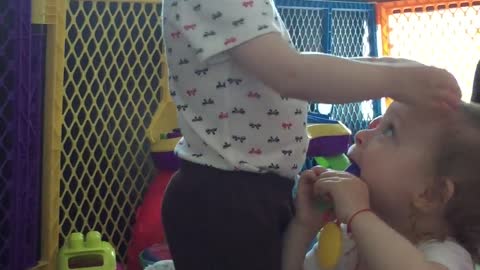Baby girl dances and drums on her twin sister's head