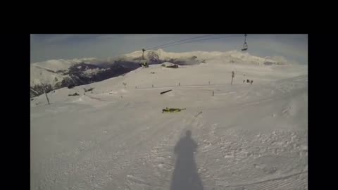 Guy skiing off a ledge falls over face first into the snow