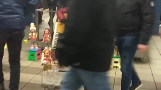 Man plays guitar at subway station with dancing dolls