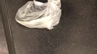 Person with plastic bags around shoes subway
