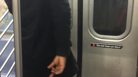 Backwards hat headphones guy dances in front of subway doors