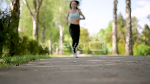 Sportswoman Running At The Park In A Sunny Day