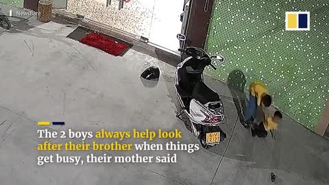 Chinese boys lift scooter to free trapped brother