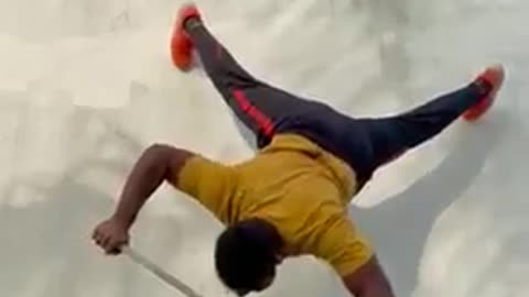 Man Performs Pushups With His Feet On Wall While Balancing on Stick