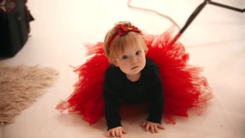Baby girl with a red tutu during a photoshoot