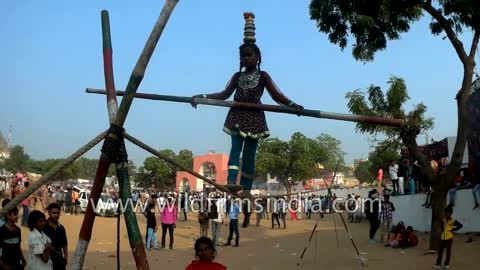 Indian girl performs street acrobatics at Pushkar, balances atop a rope