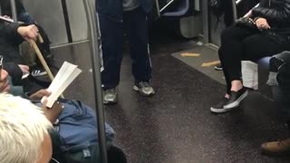 Guy makes a beat with his mouth and claps his hands on subway train