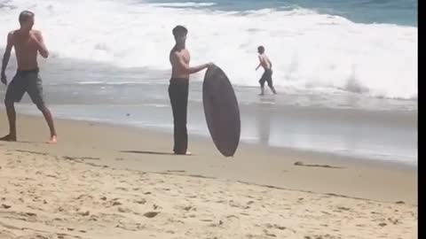 Guy in black jeans fails at jumping on surf board