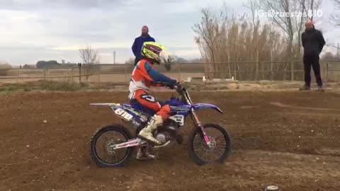 Guy in orange jumpsuit rides purple motorcross bike