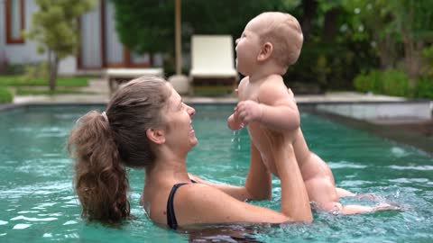 mother playing with her child in the pool
