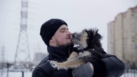 Playful dog licking owner lips outdoor winter