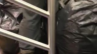 Guy with a bunch of huge black trash bags on subway