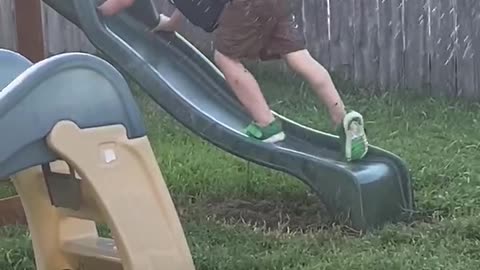 Kid Tries Climbing up Wet Slide