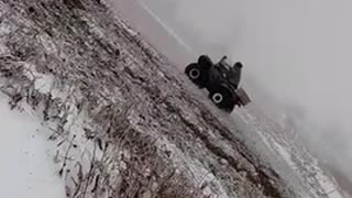 Man flips over on green snow mobile