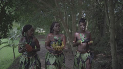 The wonderful African American ladies wearing leaves as they walk in the forest