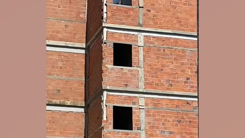 Bricklayer makes structural columns in building using PVC pipe